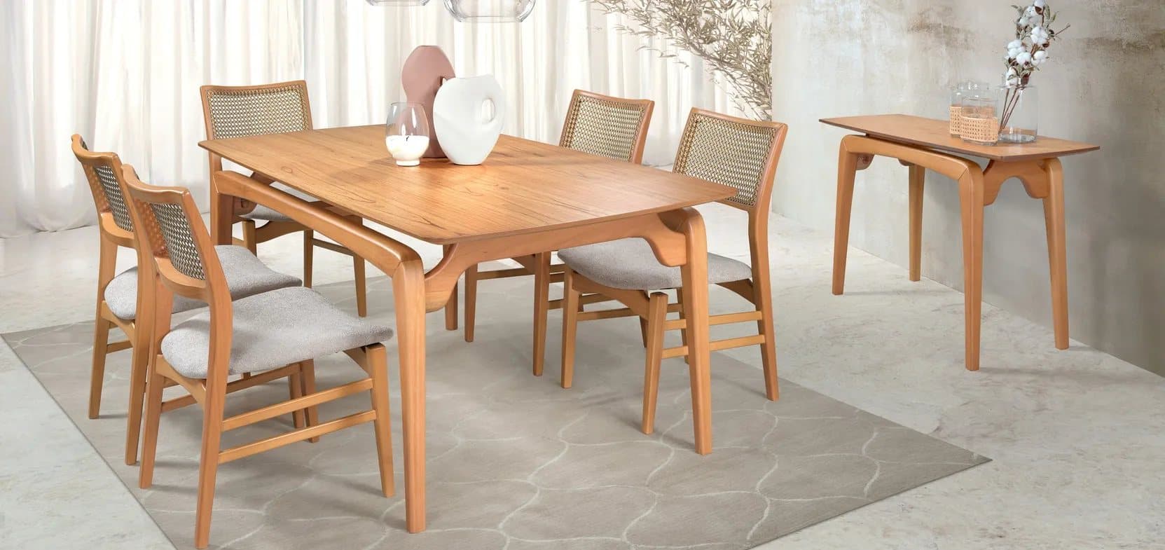 Sala de jantar montada com mesa, cadeiras de palha natural e aparador em madeira